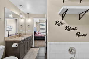 Ensuite bathroom with vanity, a bath, and light tile patterned floors