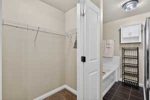 Walk in closet with dark tile patterned floors