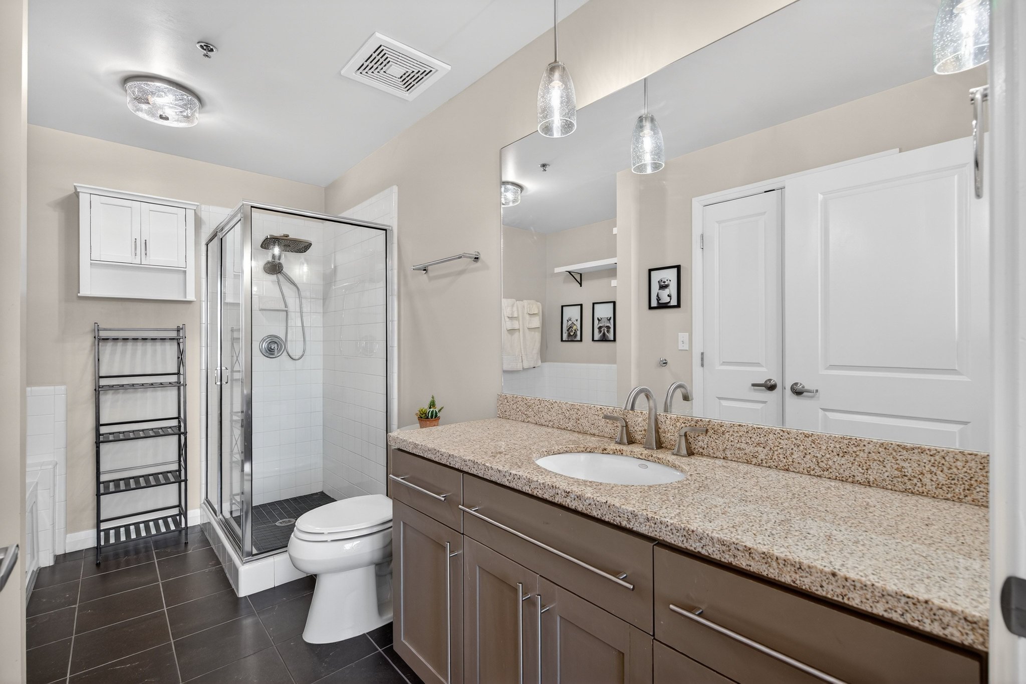 Full bathroom featuring a shower stall, dark tile patterned floors, and vanity