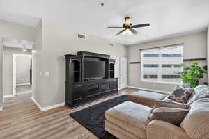 Living area with light wood finished floors and ceiling fan