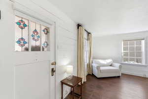 Living area featuring dark wood-style flooring and wood walls