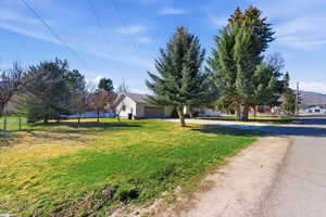View of front of house with concrete driveway, a front lawn, and a garage