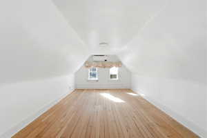 Bonus room featuring baseboards and light wood-type flooring