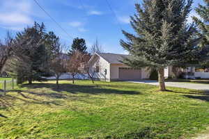 View of yard featuring concrete driveway and an attached garage