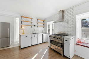 Kitchen with white cabinets, stainless steel appliances, open shelves, and plenty of natural light