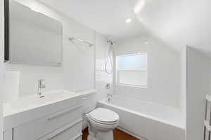 Full bath with vanity, lofted ceiling, shower / washtub combination, dark wood-style floors, and recessed lighting