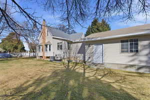 Back of house with a chimney, entry steps, and a shingled roof