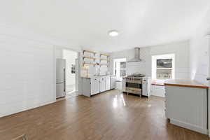 Kitchen featuring white cabinets, stainless steel appliances, open shelves, light wood finished floors, and backsplash