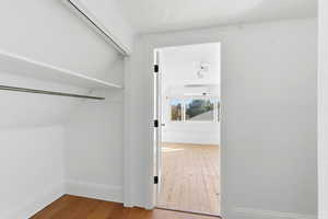 Walk in closet featuring light wood-type flooring and a wall unit AC