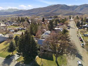 Aerial view of property and surrounding area featuring a mountain backdrop and nearby suburban area