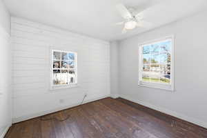 Empty room with dark wood-style floors and ceiling fan