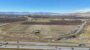 Aerial view of property and surrounding area with rural landscape, farmland, and a mountain backdrop