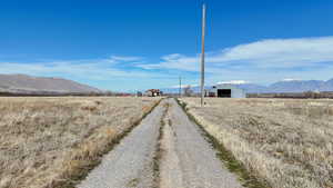 View of road featuring a mountain view, a pole building, and a view of rural / pastoral area