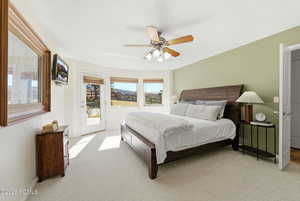 Bedroom with access to exterior, light carpet, and ceiling fan