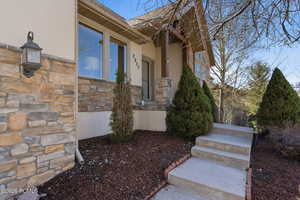 Property entrance featuring stone siding and stucco siding