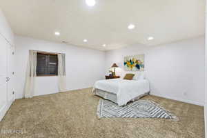 Bedroom with light carpet and recessed lighting