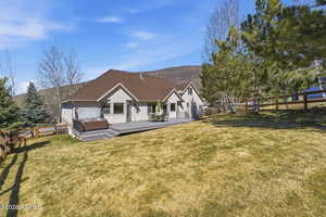 Rear view of property with a fenced backyard, a hot tub, and a deck with mountain view