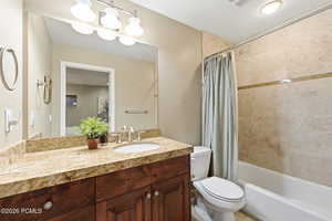 Full bath featuring vanity, shower / bath combination with curtain, and a textured ceiling