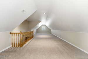 Additional living space with light carpet and baseboards