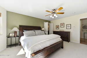 Bedroom with light carpet and a ceiling fan