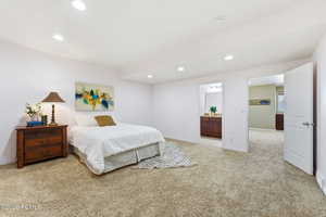 Bedroom featuring recessed lighting, light colored carpet, and connected bathroom
