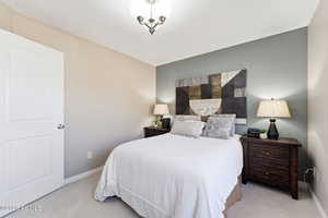 Bedroom featuring light carpet and baseboards