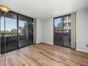 Empty room featuring floor to ceiling windows and light wood-style floors