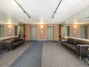 Common area with rail lighting and brick wall