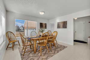Dining area with light floors and a textured ceiling