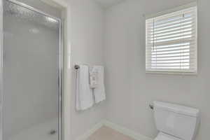 Full bath with baseboards and a stall shower