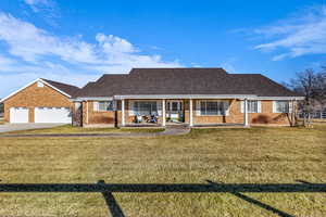 View of front of house featuring a front yard, a porch, and brick siding