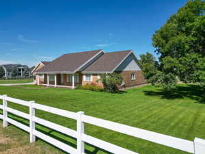 Ranch-style house featuring a fenced front yard, a porch, and brick siding
