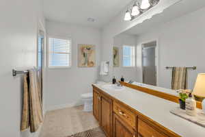 Full bath featuring a stall shower, vanity, and light floors
