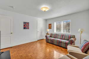 Living room with a textured ceiling and parquet floors