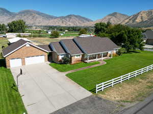 Ranch-style home featuring a porch, brick siding, a mountain view, and driveway
