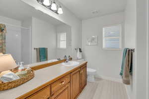 Bathroom with vanity, curtained shower, and light floors