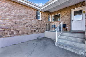 View of exterior entry featuring brick siding