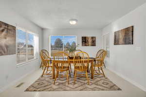 Dining room featuring a textured ceiling and baseboards
