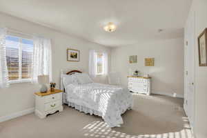 Bedroom featuring light colored carpet and a textured ceiling