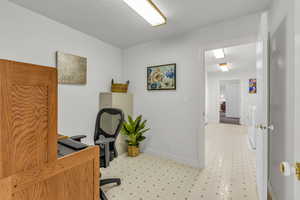 Home office featuring light flooring and a textured ceiling