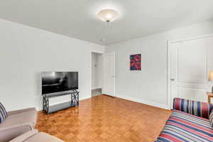 Living area with parquet flooring and a textured ceiling