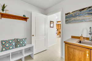Mudroom featuring light flooring and a sink