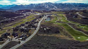 Aerial view of property's location featuring a golf club and a water and mountain view