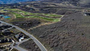 Aerial overview of property's location with a mountainous background and a golf course