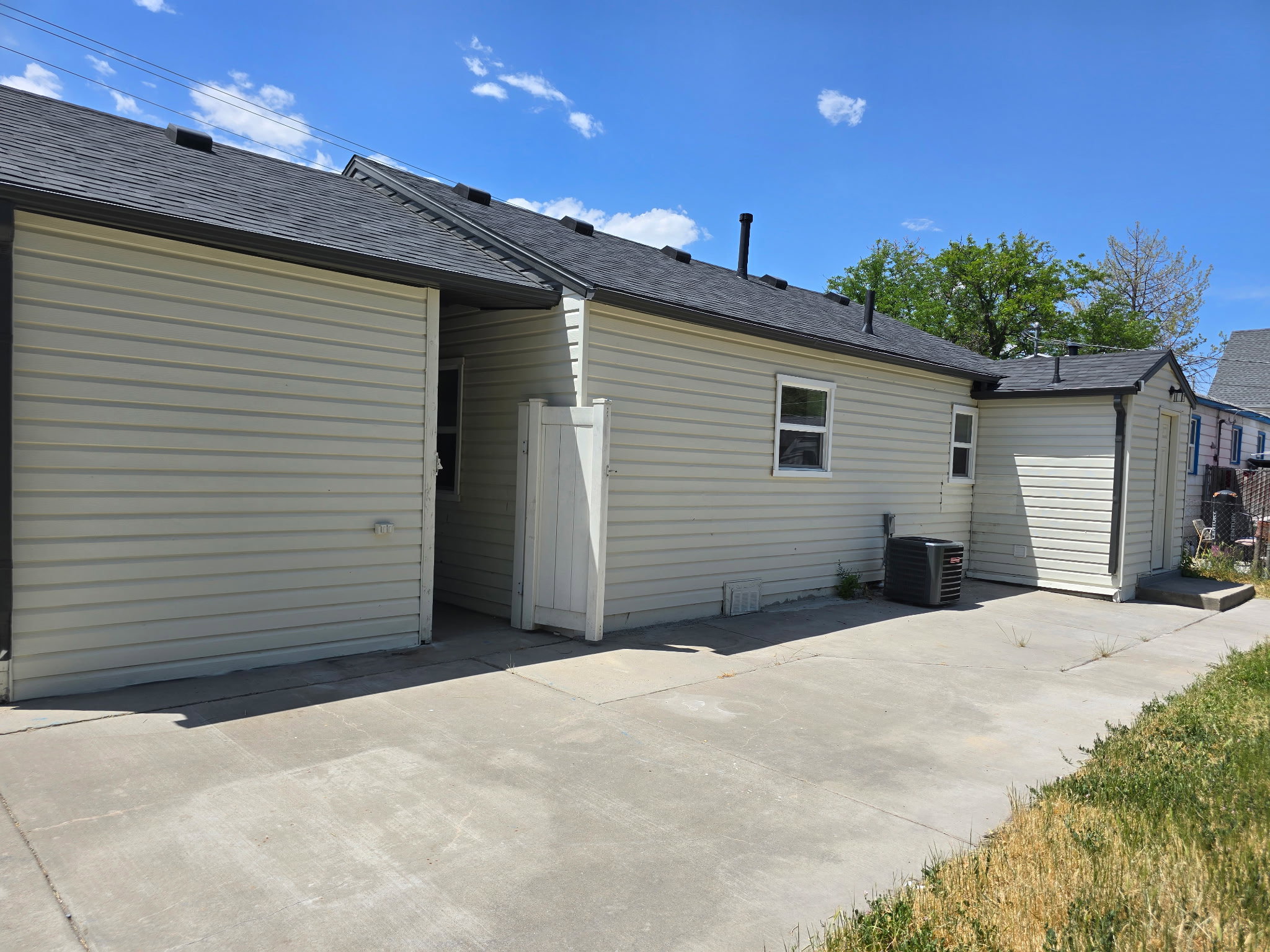 Rear view of house with a shingled roof and a patio