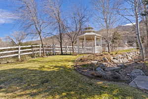 Fenced yard with a gazebo and a mountain view