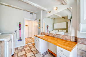 Full bath featuring separate washer and dryer, vanity, a shower with shower curtain, and beamed ceiling