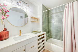 Full bath featuring vanity and shower / bathtub combination with curtain