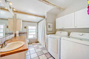 Laundry area with washing machine and clothes dryer, tile walls, and wainscoting