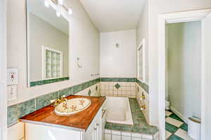 Bathroom featuring a bath, vanity, and tile patterned floors